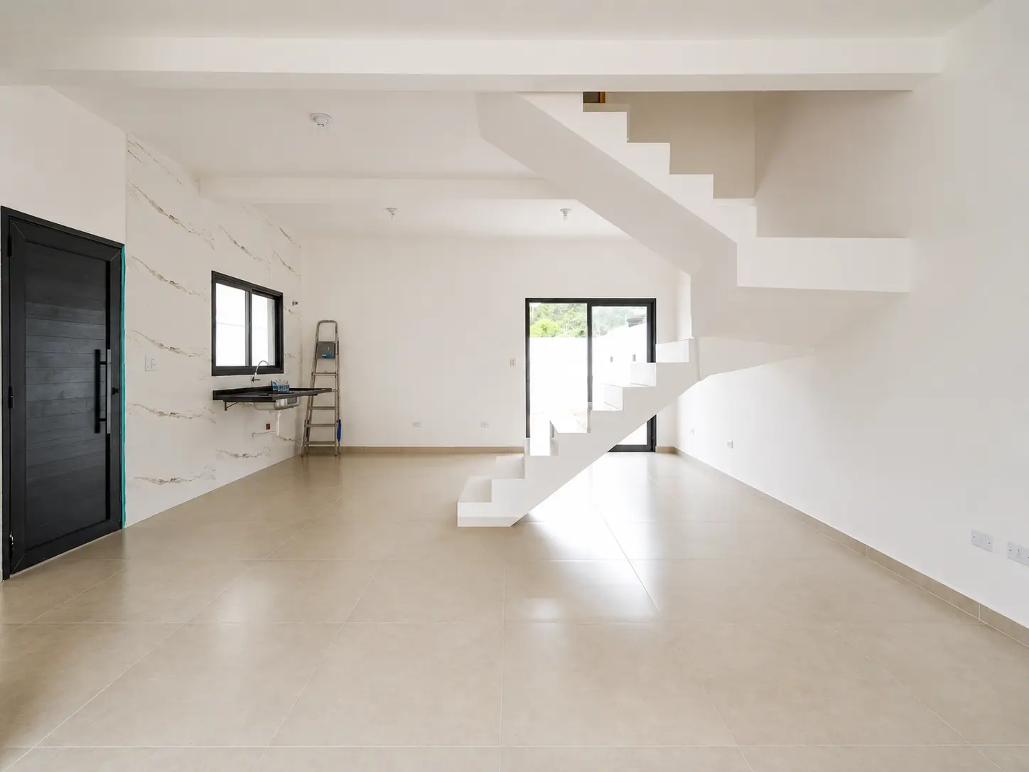Sala ampla com escada e porta de entrada